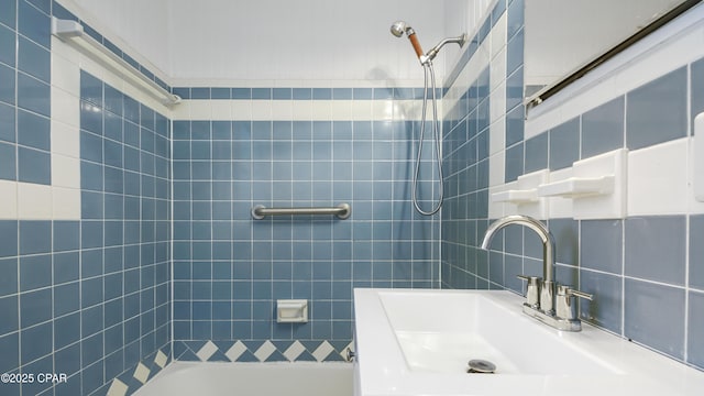 bathroom featuring tiled shower / bath, sink, and decorative backsplash