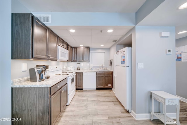 9850 S Thomas Dr Unit 806W, Panama City Beach, FL 32408 - kitchen featuring white appliances, light countertops, recessed lighting, dark brown cabinets, and light wood finished floors