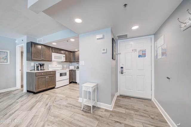 9850 S Thomas Dr Unit 806W, Panama City Beach, FL 32408 - kitchen with white appliances, light wood-type flooring, light countertops, recessed lighting, and dark brown cabinets
