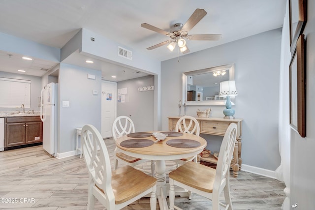 dining space with ceiling fan and sink