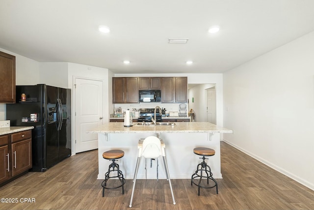 kitchen with sink, a center island with sink, and black appliances