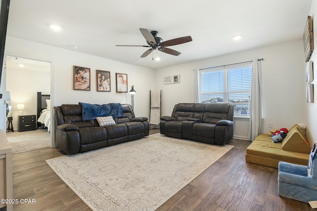 living room featuring ceiling fan and dark hardwood / wood-style floors