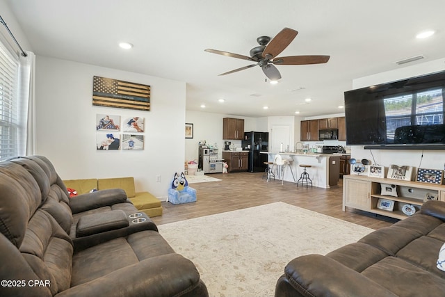 living room with hardwood / wood-style flooring, ceiling fan, and plenty of natural light