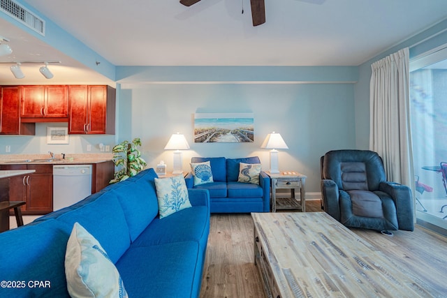 living room with ceiling fan, track lighting, and light hardwood / wood-style floors