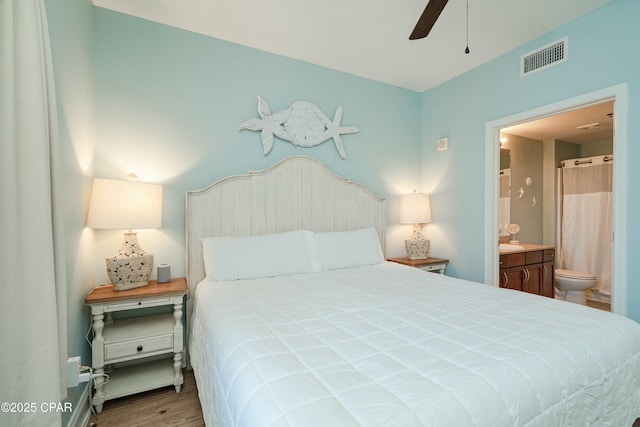 bedroom featuring ensuite bathroom, wood-type flooring, and ceiling fan