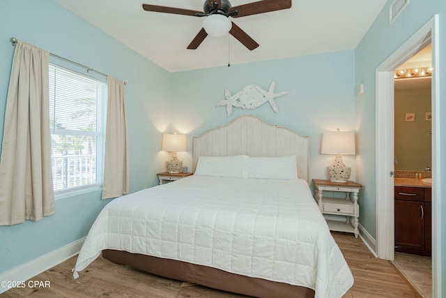 bedroom featuring ceiling fan, ensuite bathroom, and light hardwood / wood-style flooring