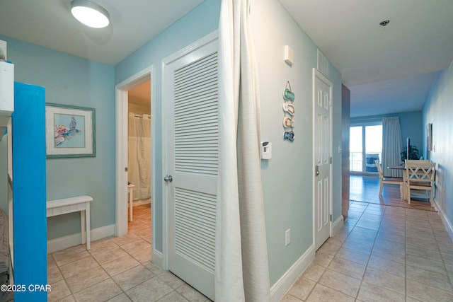 hall featuring light tile patterned floors