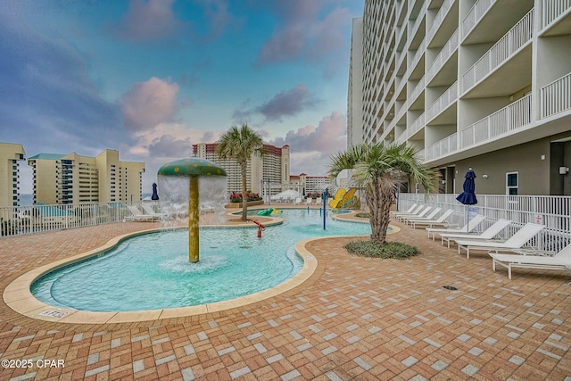 view of swimming pool with pool water feature and a patio area