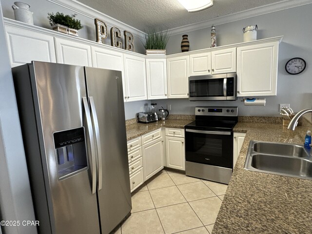 kitchen with sink, white cabinetry, a textured ceiling, ornamental molding, and stainless steel appliances