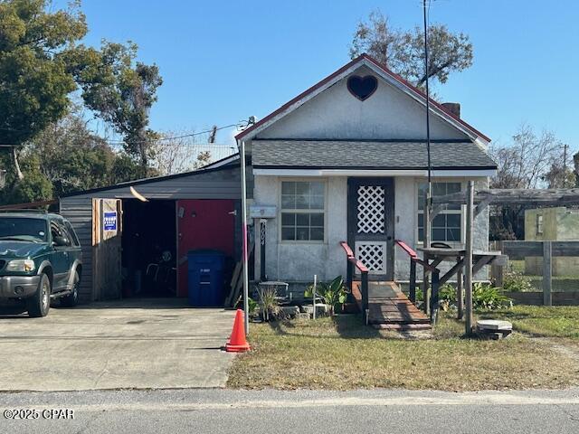 view of front of home with concrete driveway, an attached carport, and stucco siding