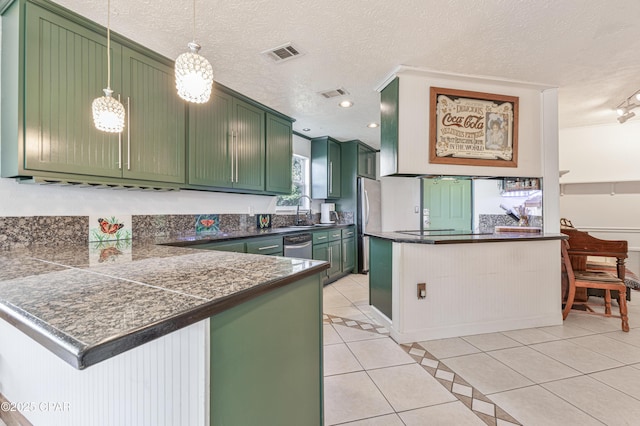 kitchen featuring pendant lighting, green cabinets, light tile patterned floors, and kitchen peninsula