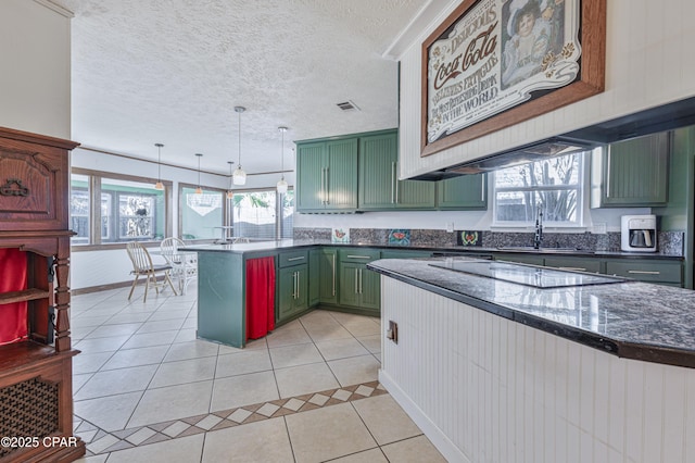 kitchen with light tile patterned flooring, hanging light fixtures, black electric cooktop, kitchen peninsula, and green cabinets