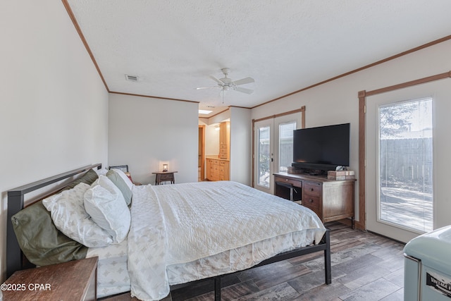 bedroom with multiple windows, ornamental molding, hardwood / wood-style flooring, and a textured ceiling