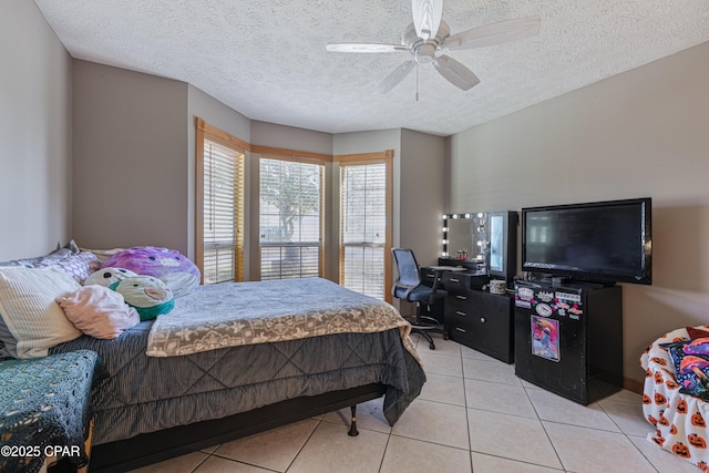 bedroom featuring light tile patterned flooring, ceiling fan, and a textured ceiling