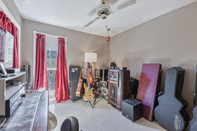 miscellaneous room featuring ceiling fan, a textured ceiling, and carpet