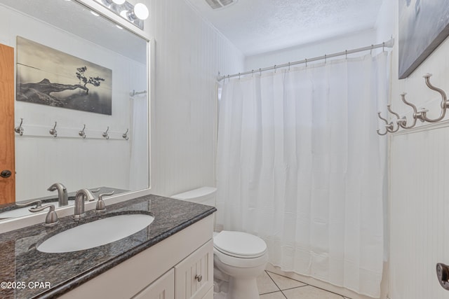 bathroom with vanity, toilet, tile patterned flooring, and a textured ceiling