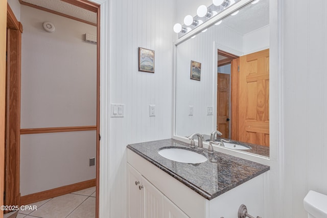 bathroom featuring tile patterned flooring, vanity, and toilet