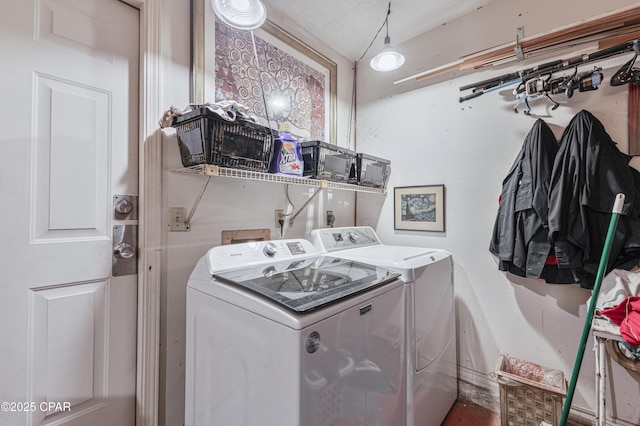 laundry room with separate washer and dryer and a textured ceiling