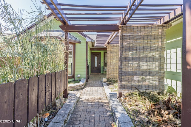 view of exterior entry with a pergola