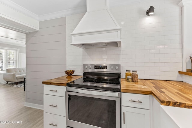 kitchen with premium range hood, electric range, ornamental molding, white cabinets, and wood counters