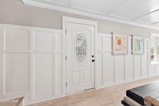 entrance foyer with crown molding and light hardwood / wood-style floors