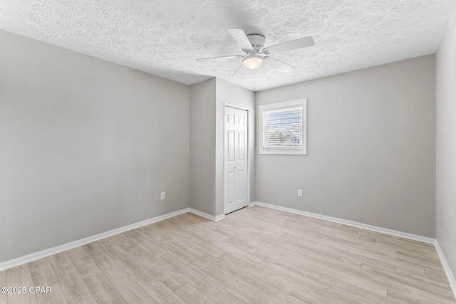 spare room with a textured ceiling, light hardwood / wood-style floors, and ceiling fan