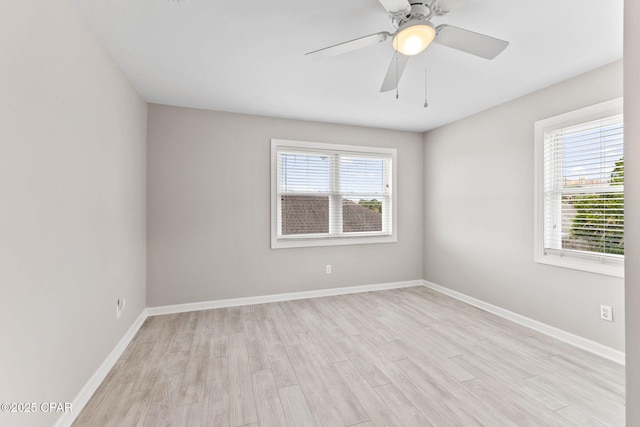 spare room with light hardwood / wood-style flooring, a wealth of natural light, and ceiling fan