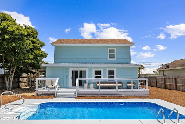 rear view of house featuring a pool side deck