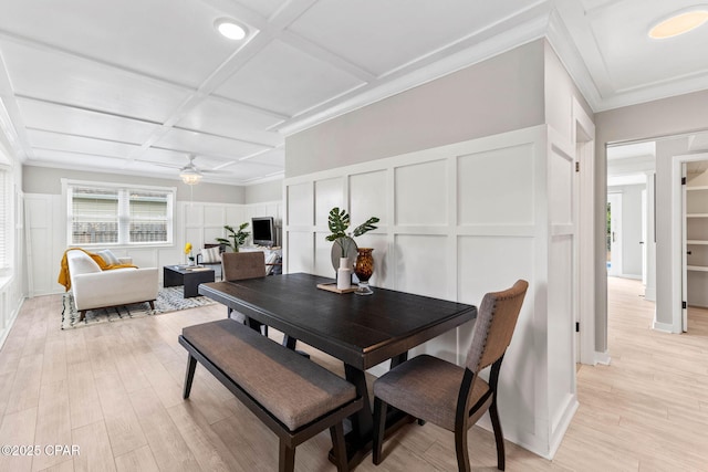 dining room featuring coffered ceiling, ornamental molding, light hardwood / wood-style floors, and ceiling fan