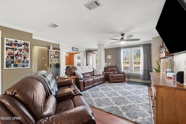 living room with decorative columns, crown molding, hardwood / wood-style flooring, and ceiling fan