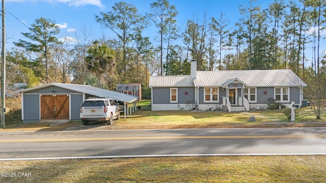 ranch-style house featuring a carport, an outbuilding, and a front lawn