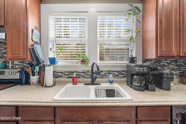 kitchen featuring tasteful backsplash, plenty of natural light, sink, and wall chimney range hood