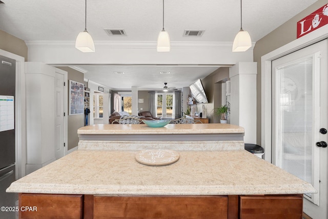 kitchen featuring pendant lighting, crown molding, and a center island