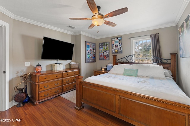 bedroom featuring hardwood / wood-style floors, crown molding, and ceiling fan