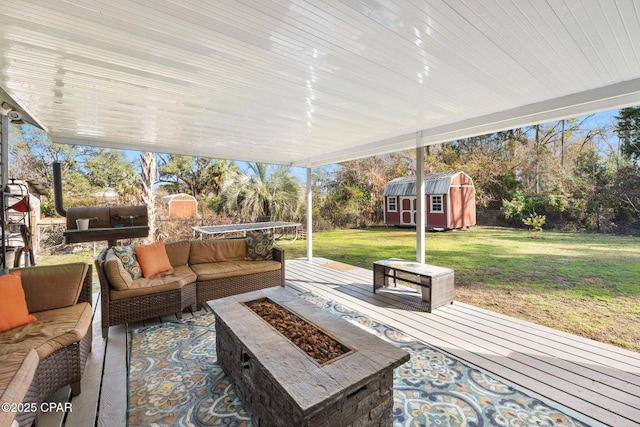 view of patio with a shed and an outdoor living space with a fire pit