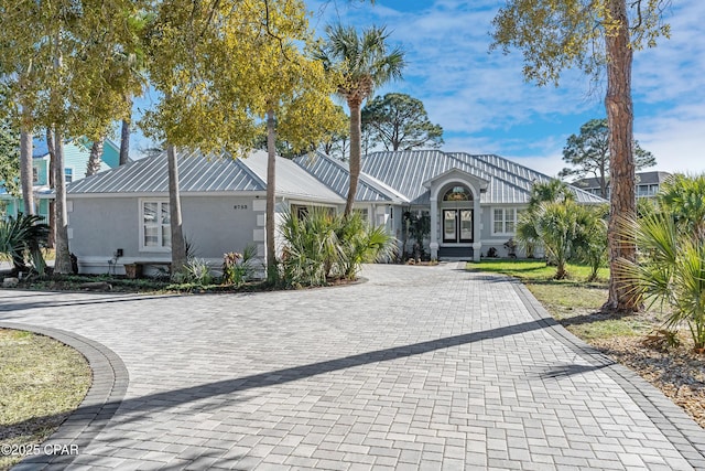 view of front of house featuring stucco siding and metal roof