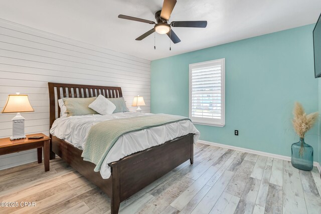 bedroom with wood walls and light wood-type flooring