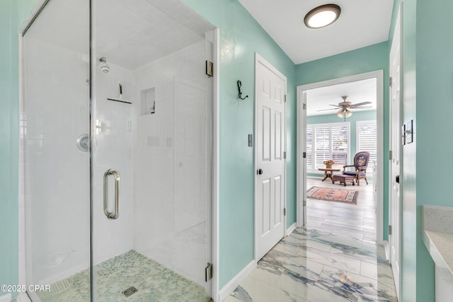 full bathroom with marble finish floor, a shower stall, and baseboards