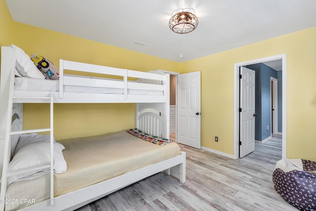 bedroom with visible vents, baseboards, and wood finished floors