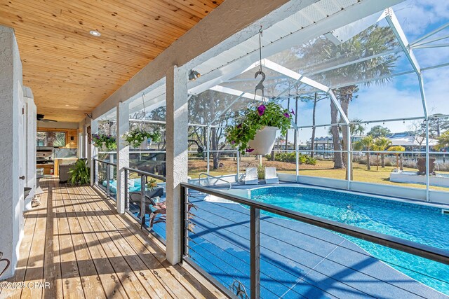 view of swimming pool featuring ceiling fan, a lanai, and a patio area