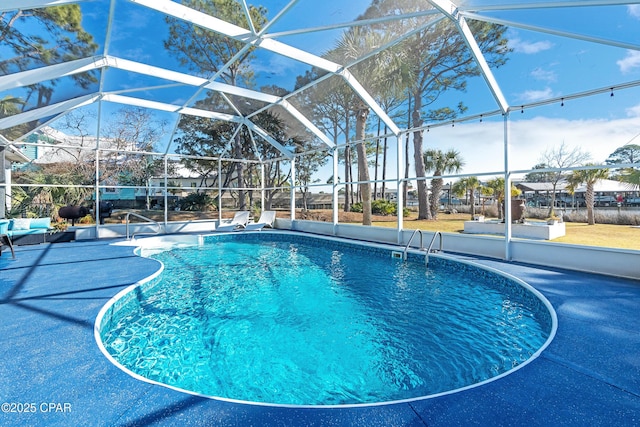 outdoor pool with glass enclosure and a patio