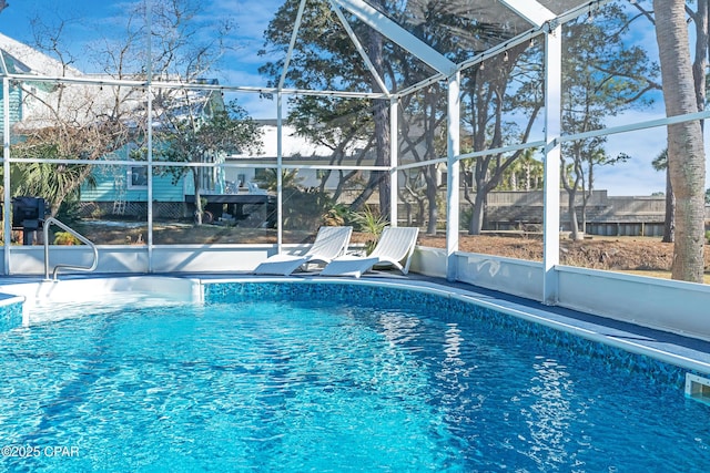 outdoor pool featuring a patio area, a lanai, and fence