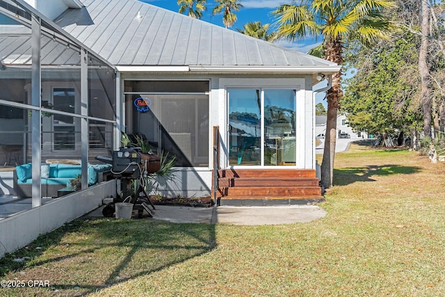 exterior space featuring a front lawn, entry steps, a standing seam roof, glass enclosure, and metal roof