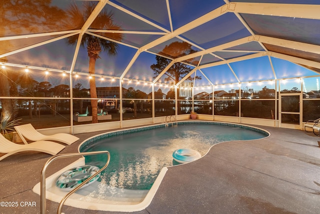 outdoor pool with glass enclosure and a patio area