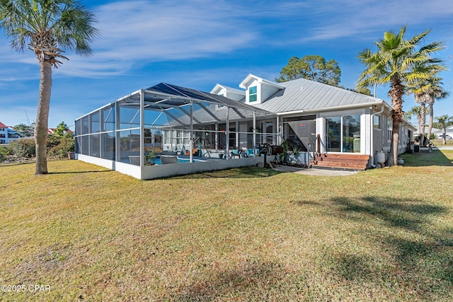 rear view of house with a lawn, an outdoor pool, metal roof, a lanai, and a patio area