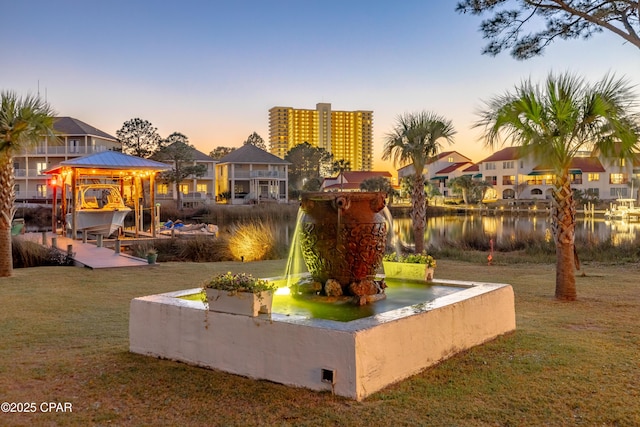 exterior space featuring a lawn and a water view