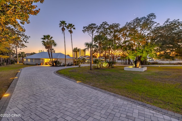 exterior space with decorative driveway and a front yard