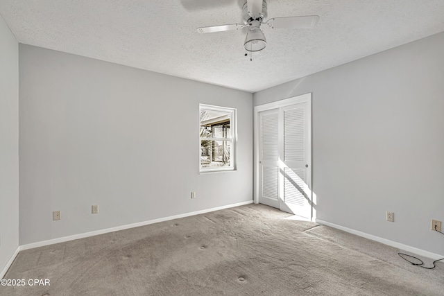 carpeted empty room with ceiling fan and a textured ceiling