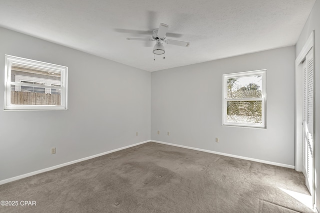 unfurnished room featuring ceiling fan, carpet, and a textured ceiling