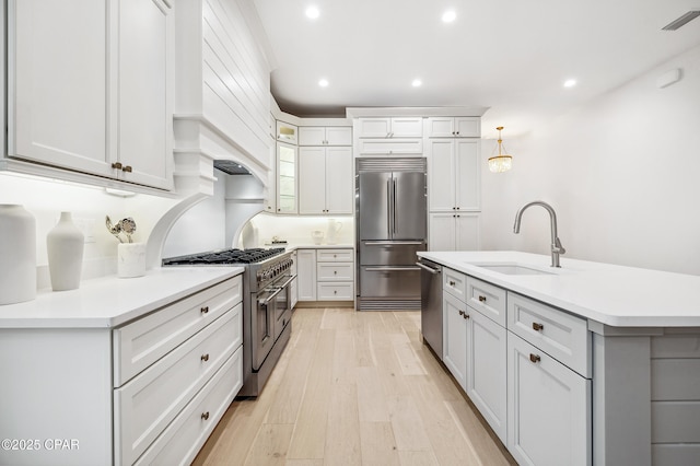 kitchen with high quality appliances, visible vents, light countertops, and a sink